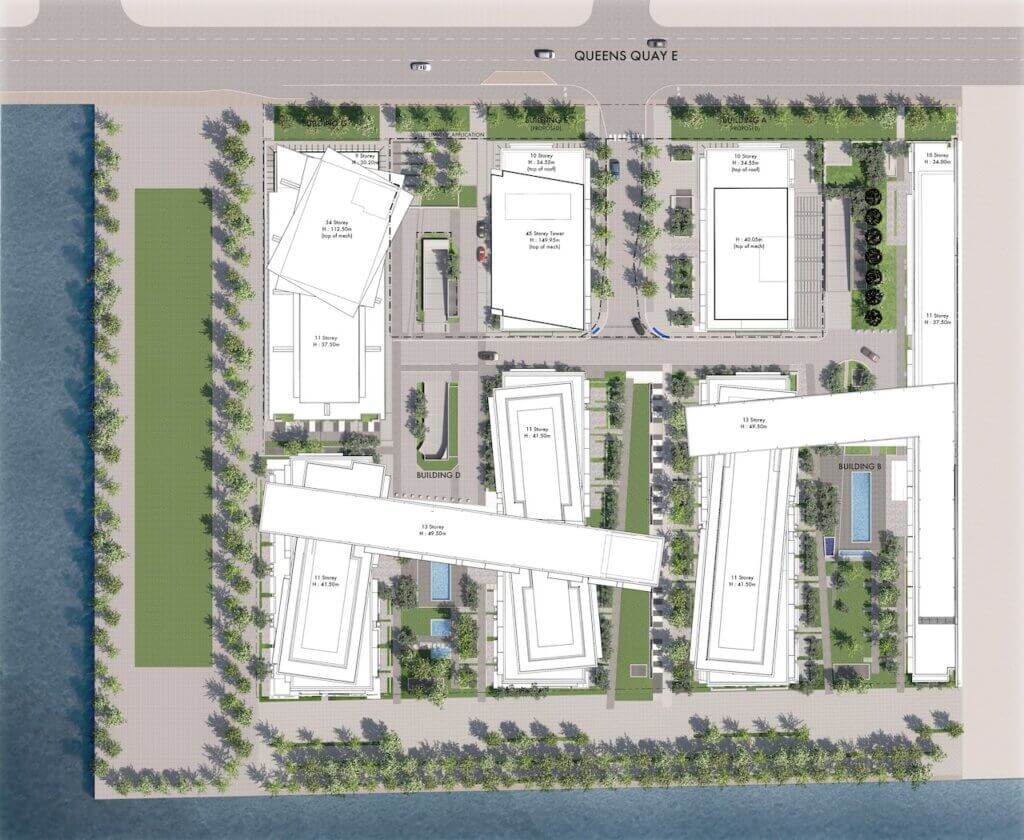 Aerial site plan of a waterfront complex showing multiple rectangular buildings, green landscaped areas, pathways, roads, and a pool, bordered by water on the left and a street labeled QUEENS QUAY E at the top.